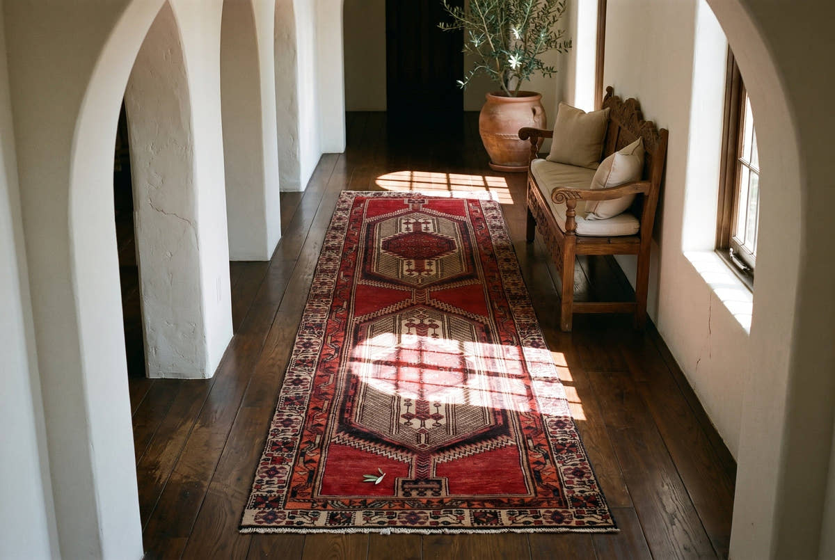 A red vintage Persian Ardabil runner down an arched hallway in a Spanish Revival house in Los Angeles