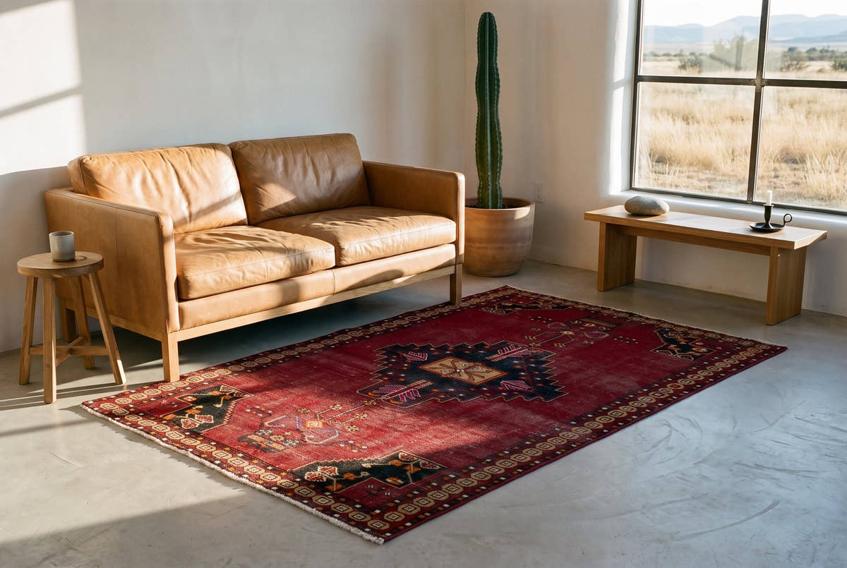 A burgundy vintage Persian Ferdos rug with a stepped medallion in a minimal adobe house in Marfa, Texas