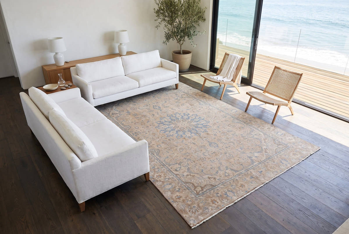 A soft sand vintage Persian Najafabad rug with a pale blue medallion in a Malibu beach house living room