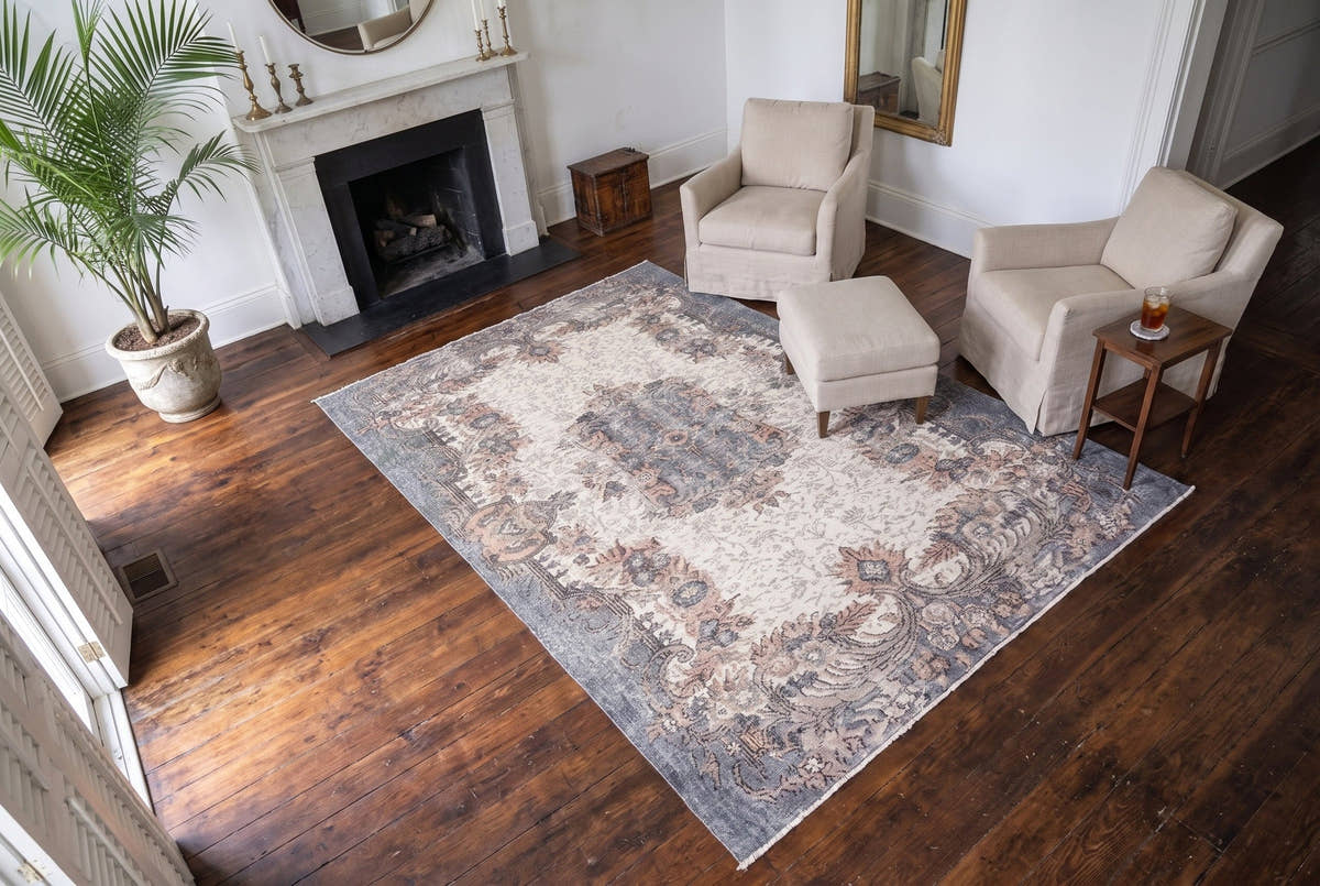 A cream vintage Turkish Isparta rug seen from above in the front parlor of a Greek Revival house in New Orleans