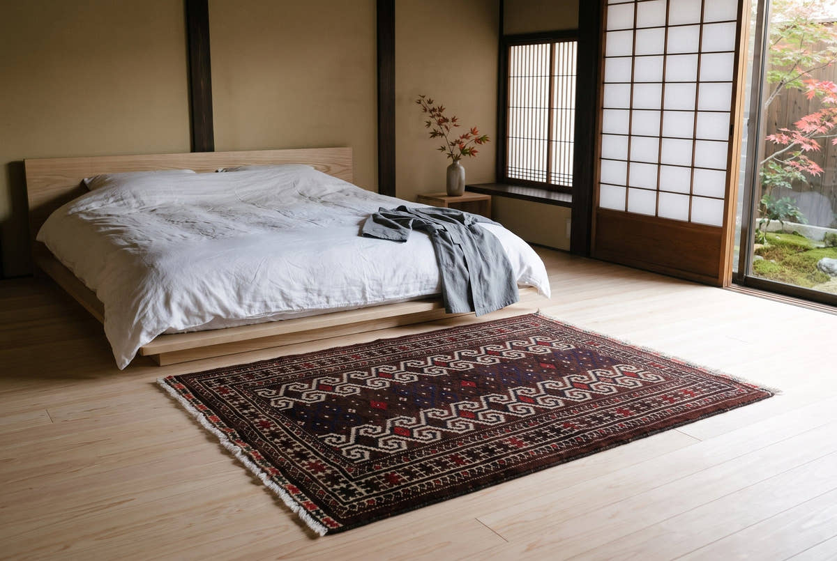 A dark vintage Persian Torkaman rug with columns of hooked motifs in a Kyoto machiya bedroom