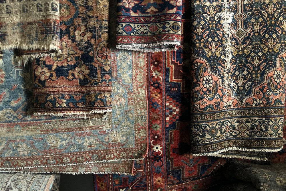 Vintage rugs stacked and rolled, ready to browse