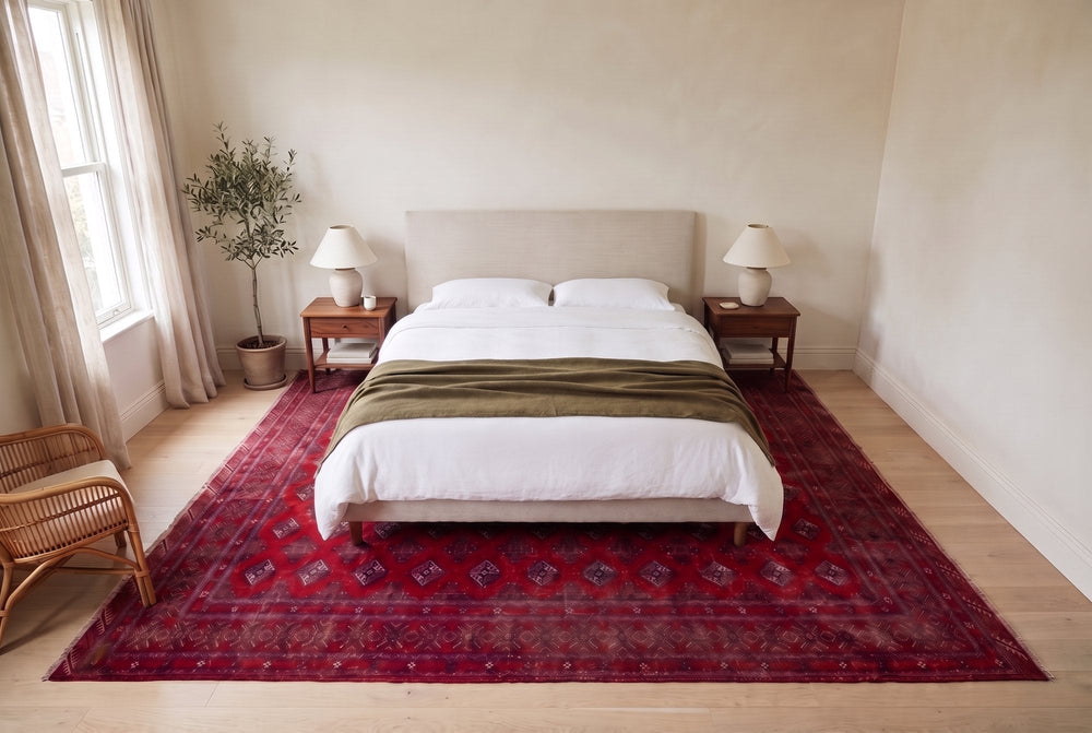 Bedroom with a king bed centered on a large red Torkaman rug laid sideways, walnut nightstands at the rug’s back edge by the wall