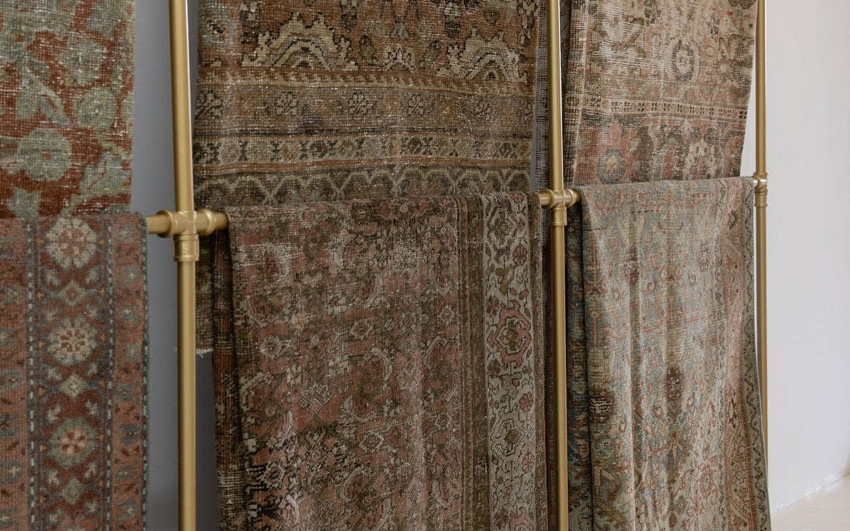 Vintage Persian rugs hanging on a gallery rail
