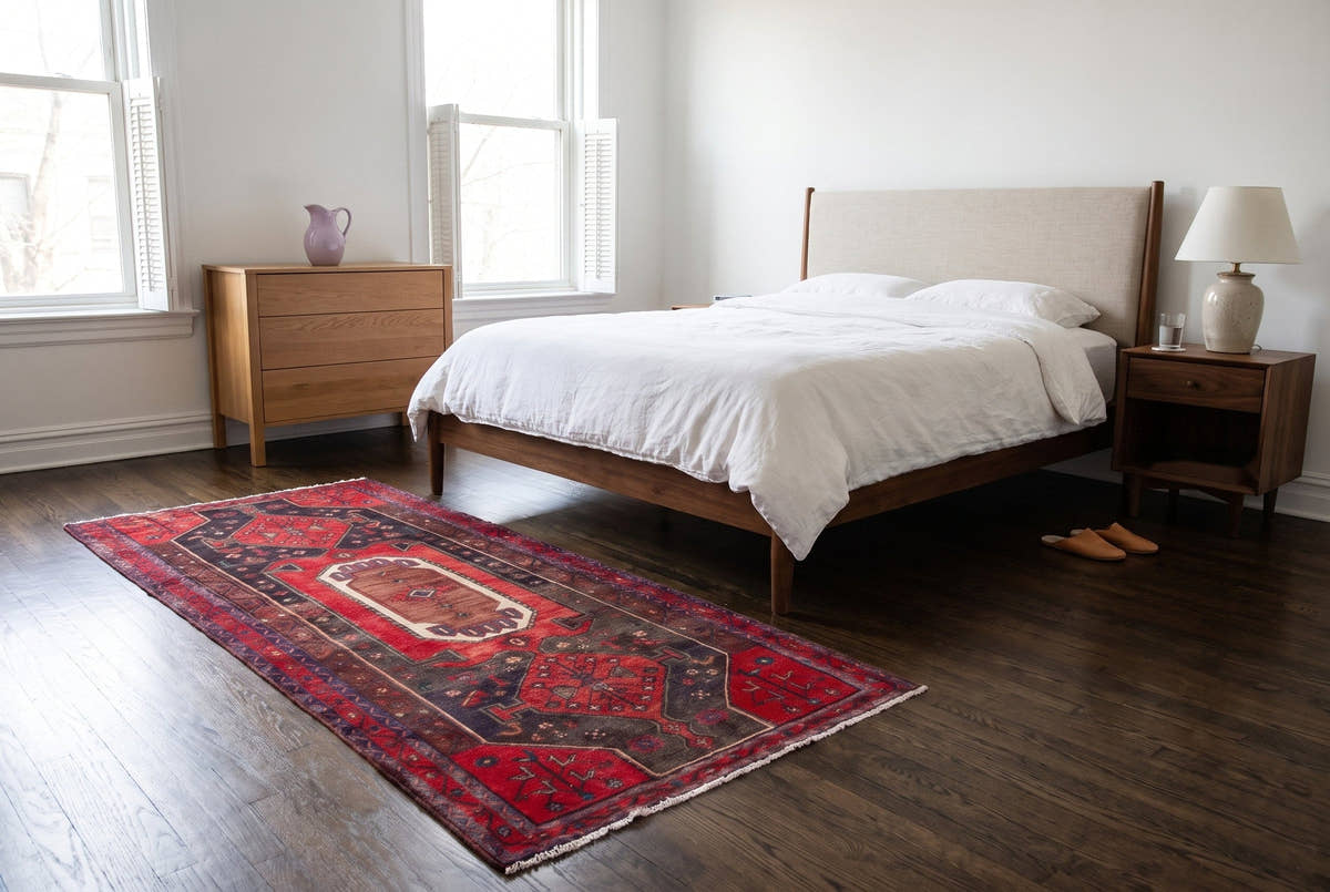 A red and dark brown vintage Persian Songhor rug in the bedroom of an 1890s greystone in Chicago’s Lincoln Park