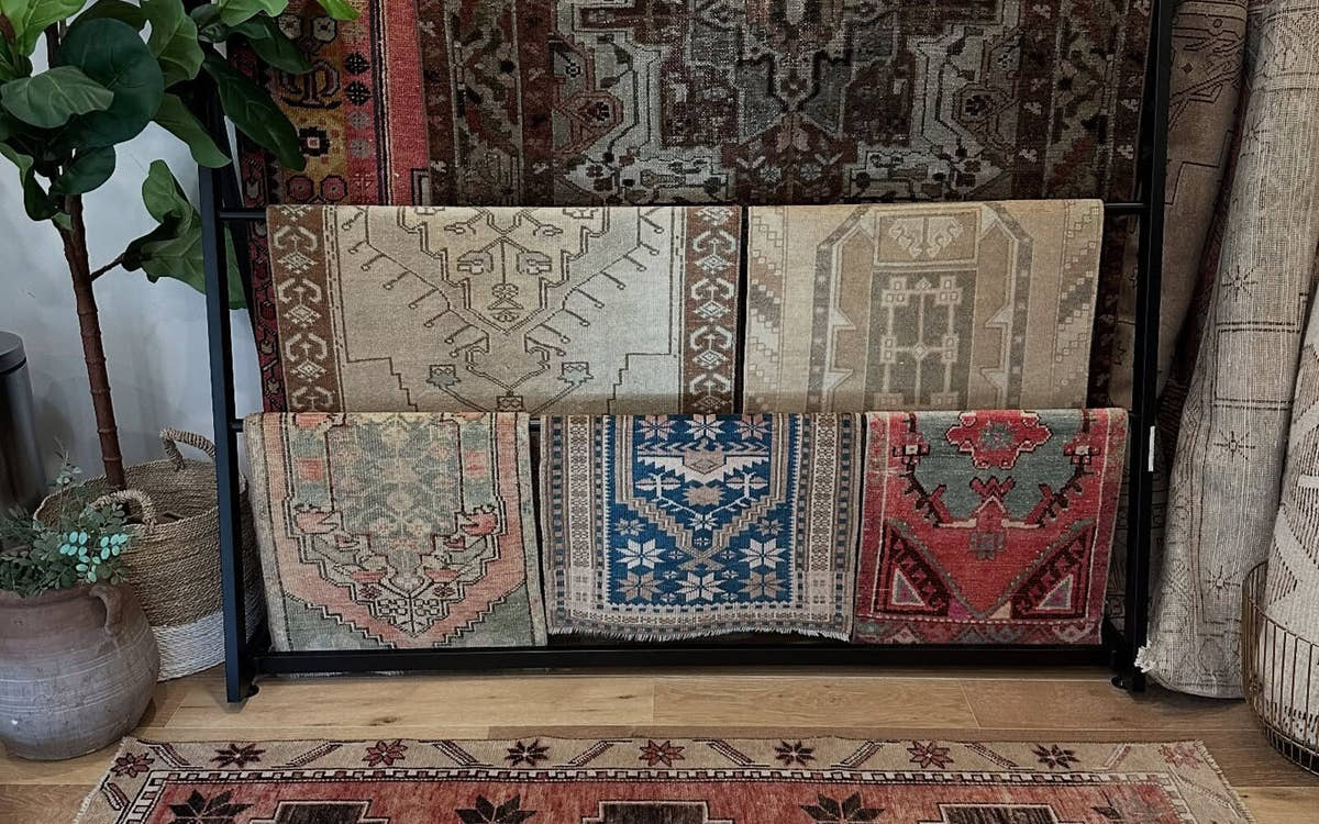 Vintage Anatolian rugs displayed on a gallery rack