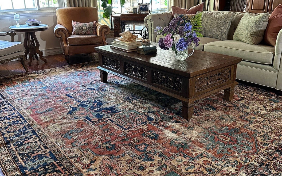 Oversized vintage Persian rug filling a living room beneath all the furniture
