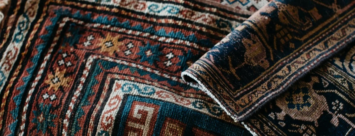 Stacked vintage Persian rugs gallery banner