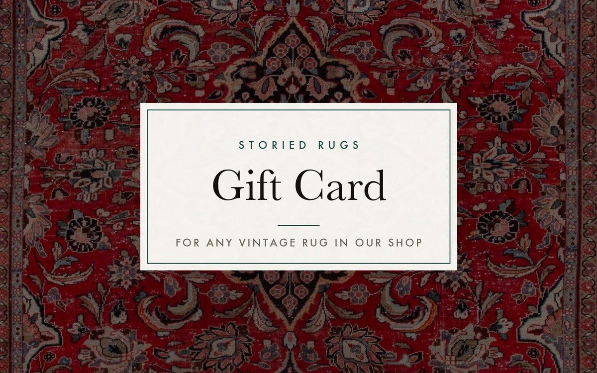 Storied Rugs gift card on a red Persian rug